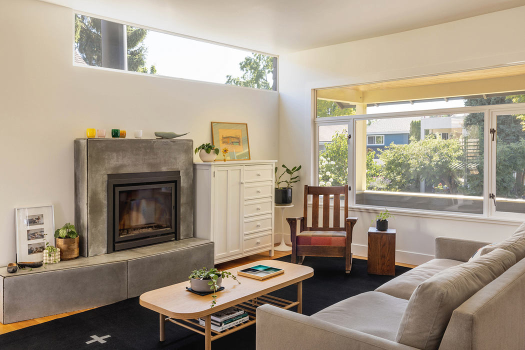 Warm, modern living room with large windows, fireplace, and mid-century furnishings.