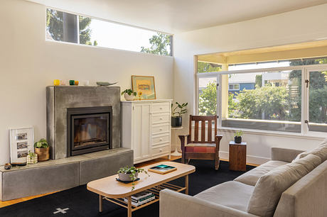 Warm, modern living room with large windows, fireplace, and mid-century furnishings.