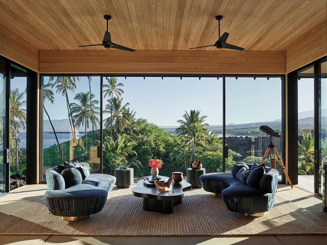 Spacious tropical living room with panoramic ocean views, plush seating, and warm wood accents.
