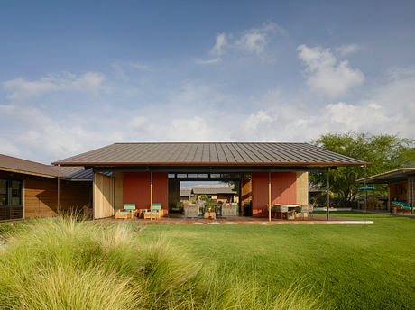 An open-concept, contemporary structure with a sweeping metal roof and wooden accents.