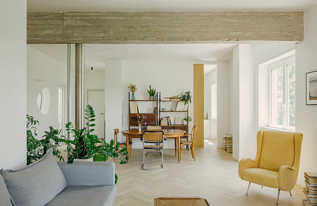 Bright, open-concept living space with rustic beams, wood furniture, and lush greenery.