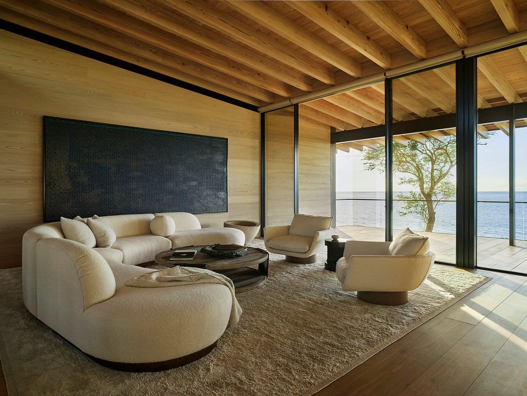 Spacious living room with wooden beams, cozy seating, and expansive views of the outdoors.