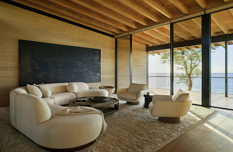 Spacious living room with wooden beams, cozy seating, and expansive views of the outdoors.