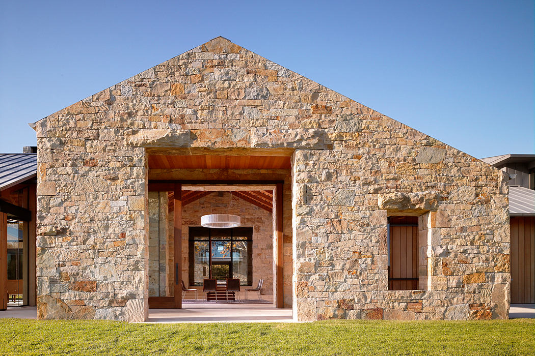 Impressive stone facade with wooden beams and arched entryway leading into inviting interior.