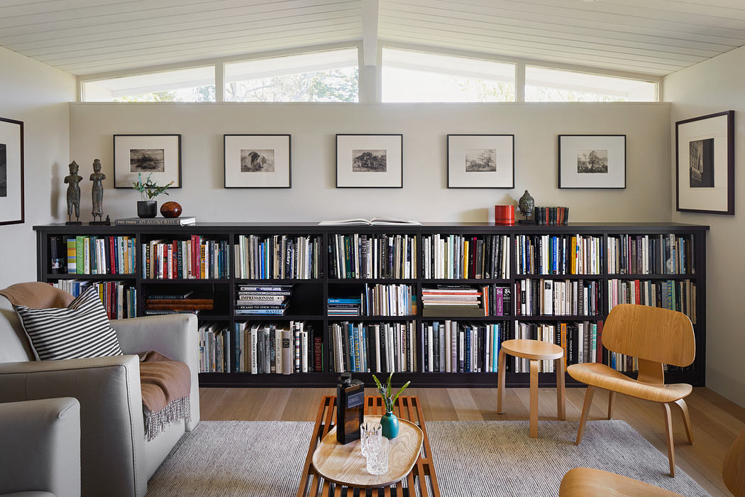Spacious living room with floor-to-ceiling bookshelves, mid-century modern furniture.
