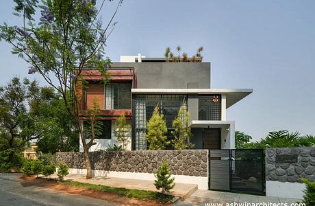 A contemporary residential building featuring a mix of materials and geometric shapes.