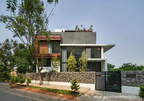 A contemporary residential building featuring a mix of materials and geometric shapes.