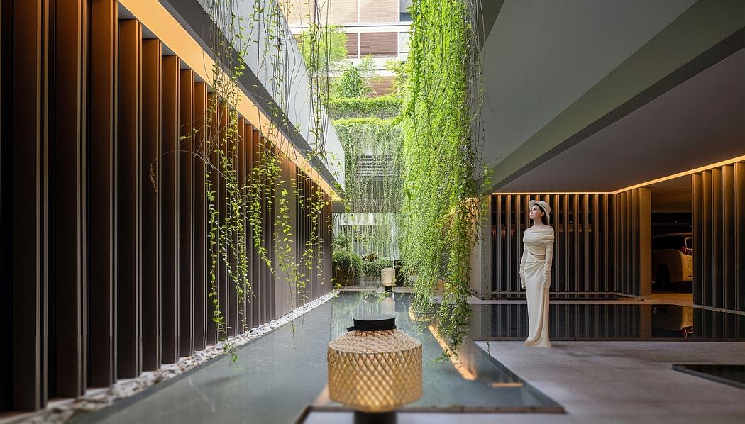 Striking modern interior with lush greenery, water feature, and elegant decor.