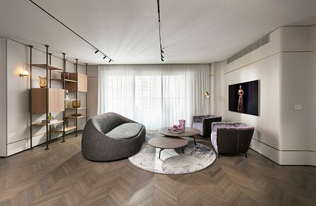 High-contrast modern living room with plush seating, shelving, and hardwood floor.