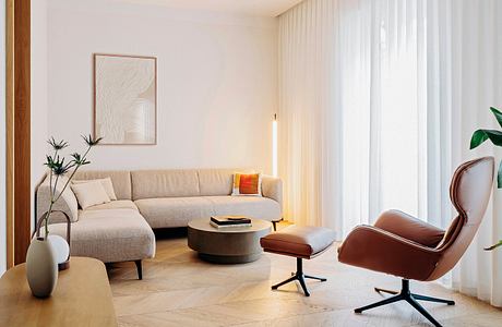 Cozy living room with a plush sectional sofa, decorative floor lamps, and a modern armchair.