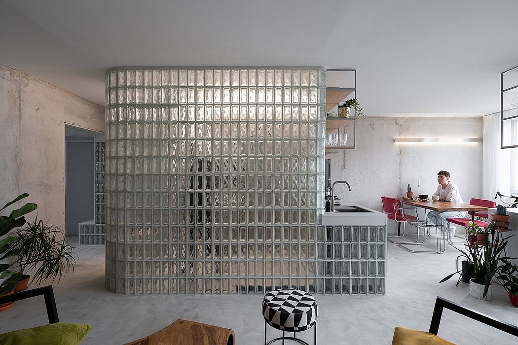 A modern, open-concept interior with a striking glass block partition dividing the spaces.