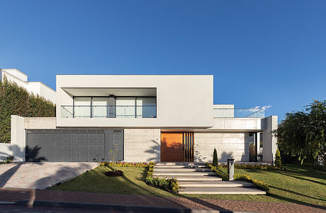 Modern, sleek exterior with clean lines, large windows, and a striking wooden entry door.