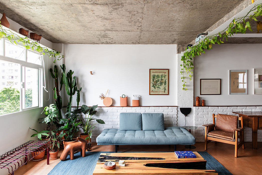 Cozy living room with cacti, potted plants, brick walls, and exposed concrete ceiling.