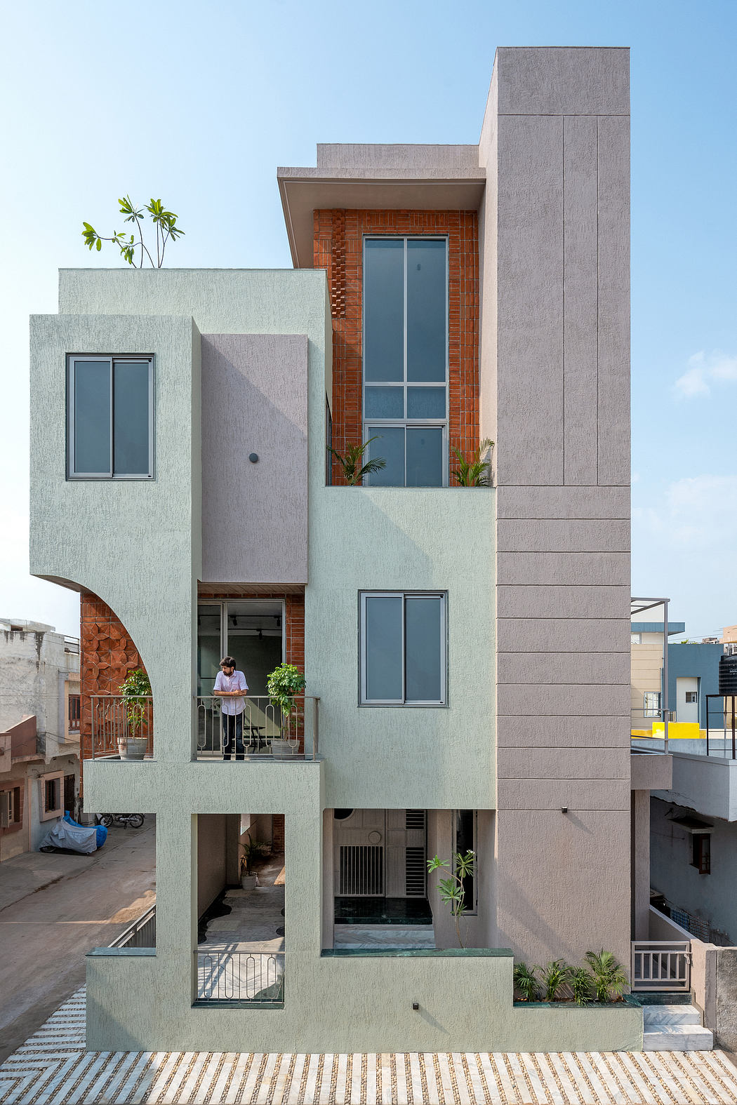 Modern multi-story residential building with clean geometric forms, contrasting materials, and balconies.