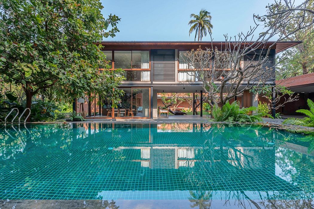A contemporary tropical house with a large swimming pool reflecting the building.