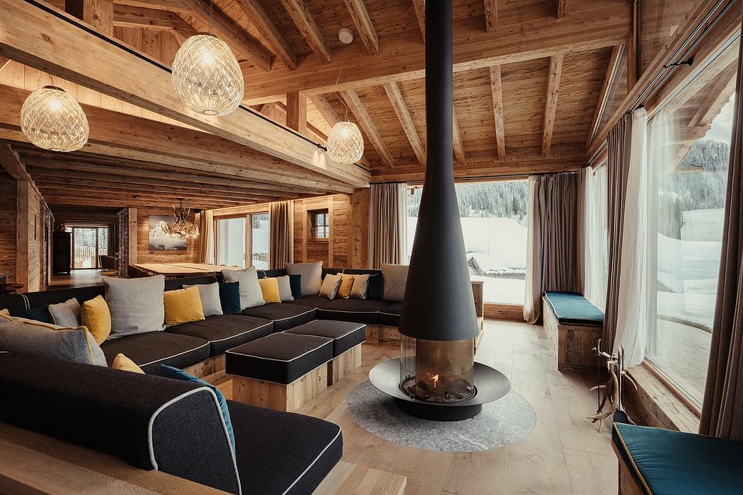 A cozy, rustic living room with a central fireplace and recessed lighting in a wooden cabin.