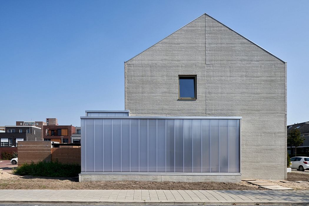 A modern, minimalist architectural design featuring a gray wooden exterior and large glass windows.