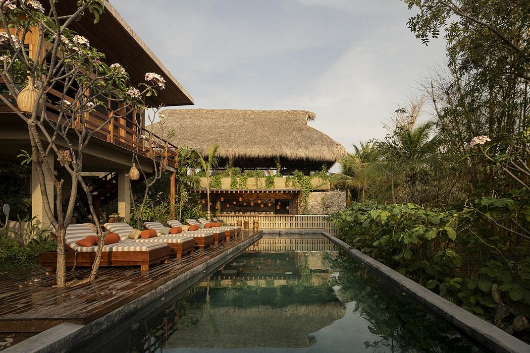 Serene tropical resort with thatched-roof structures, pool, and lush greenery.