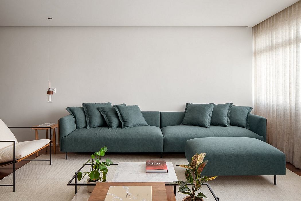 Minimalist living room with a large, comfortable green sofa and a marble coffee table.