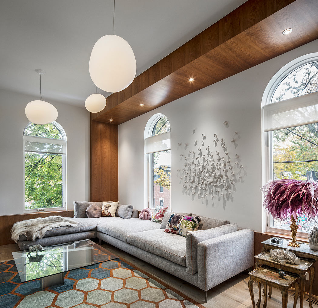 Spacious living room with wood-paneled walls, arched windows, and pendant lighting.