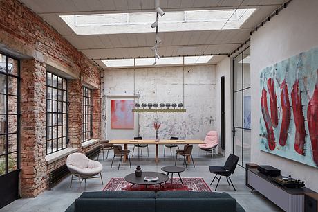 A modern industrial-style loft with exposed brick walls, high ceilings, and artistic decor.