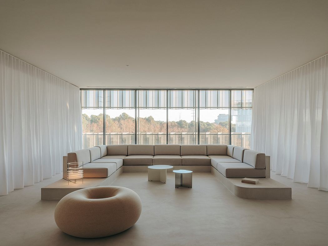 Spacious, minimalist living room with floor-to-ceiling windows showcasing natural scenery.