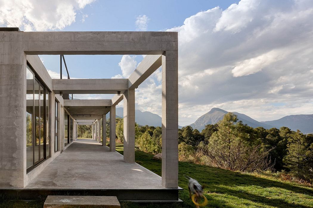Modern concrete structure with glass walls, framed views of mountain landscape.