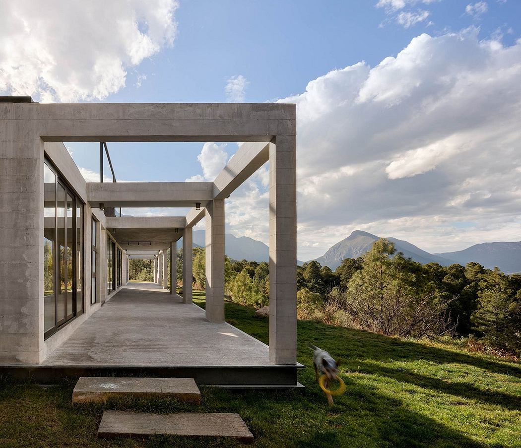 Modern concrete structure with glass walls, framed views of mountain landscape.