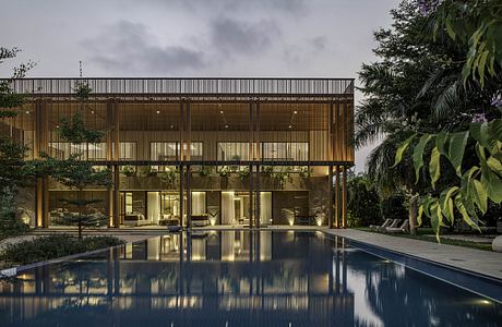 Sleek wooden facade and pool reflecting the modern tropical structure.