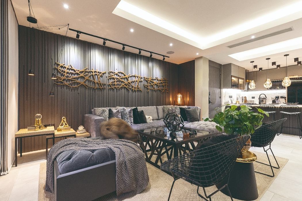 Modern and cozy living room with metallic artwork, skylights, and sleek furnishings.