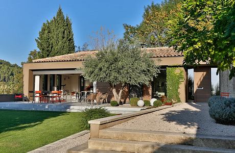 Inviting Mediterranean-style villa with terrace, pool, and lush landscaping.