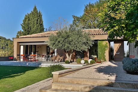 Inviting Mediterranean-style villa with terrace, pool, and lush landscaping.