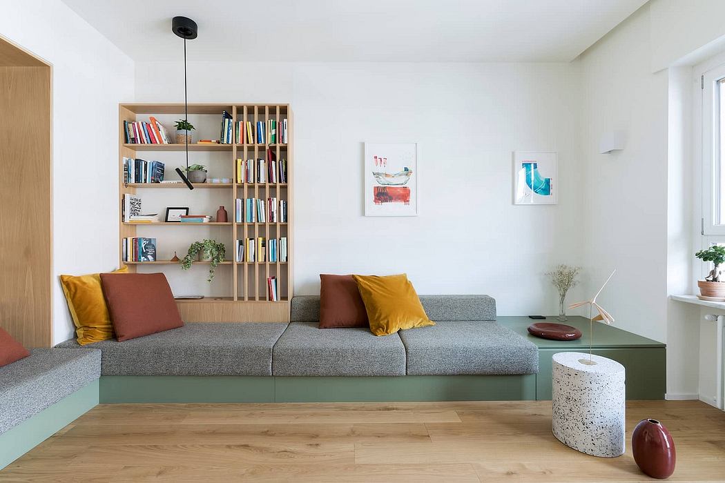Bright, modern living room with built-in bookshelves, gray sofa, and colorful accents.
