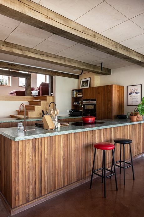 Warm, rustic kitchen design with wooden beams, countertops, and bar stools.