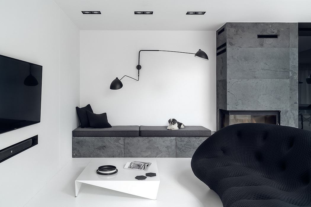 Contemporary living room with minimalist gray and black decor, sleek built-in bench, and architectural lighting.