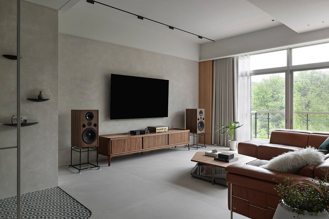 Minimalist living room with a large TV, wooden media console, and sleek audio system.