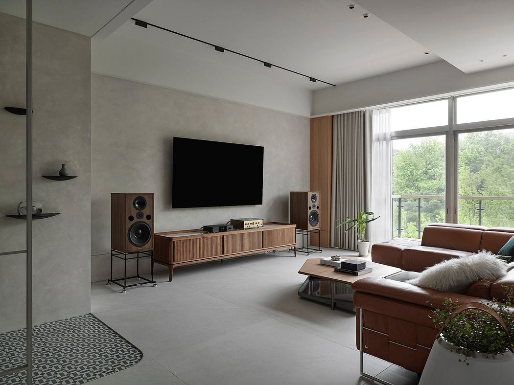 Minimalist living room with a large TV, wooden media console, and sleek audio system.