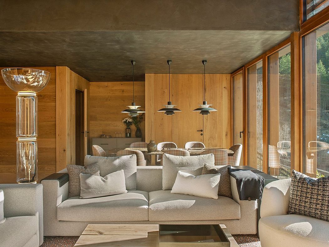 A cozy, rustic living room with wooden walls, comfortable sofas, and modern pendant lights.