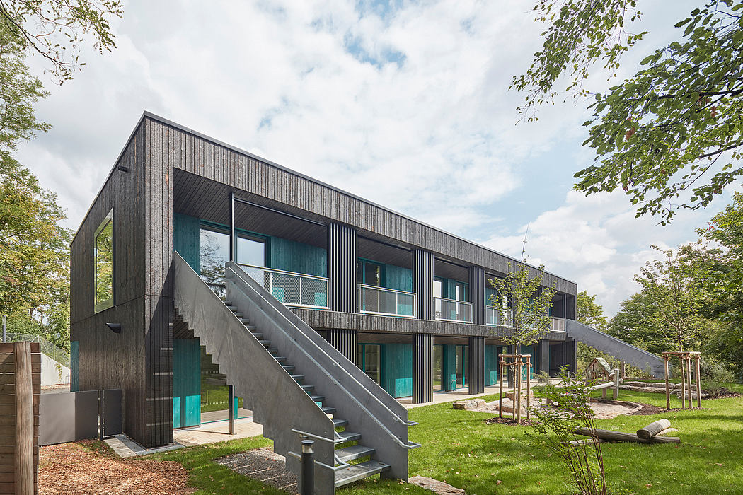 Sleek, dark wooden exterior with striking geometric patterns and large windows against green landscape.