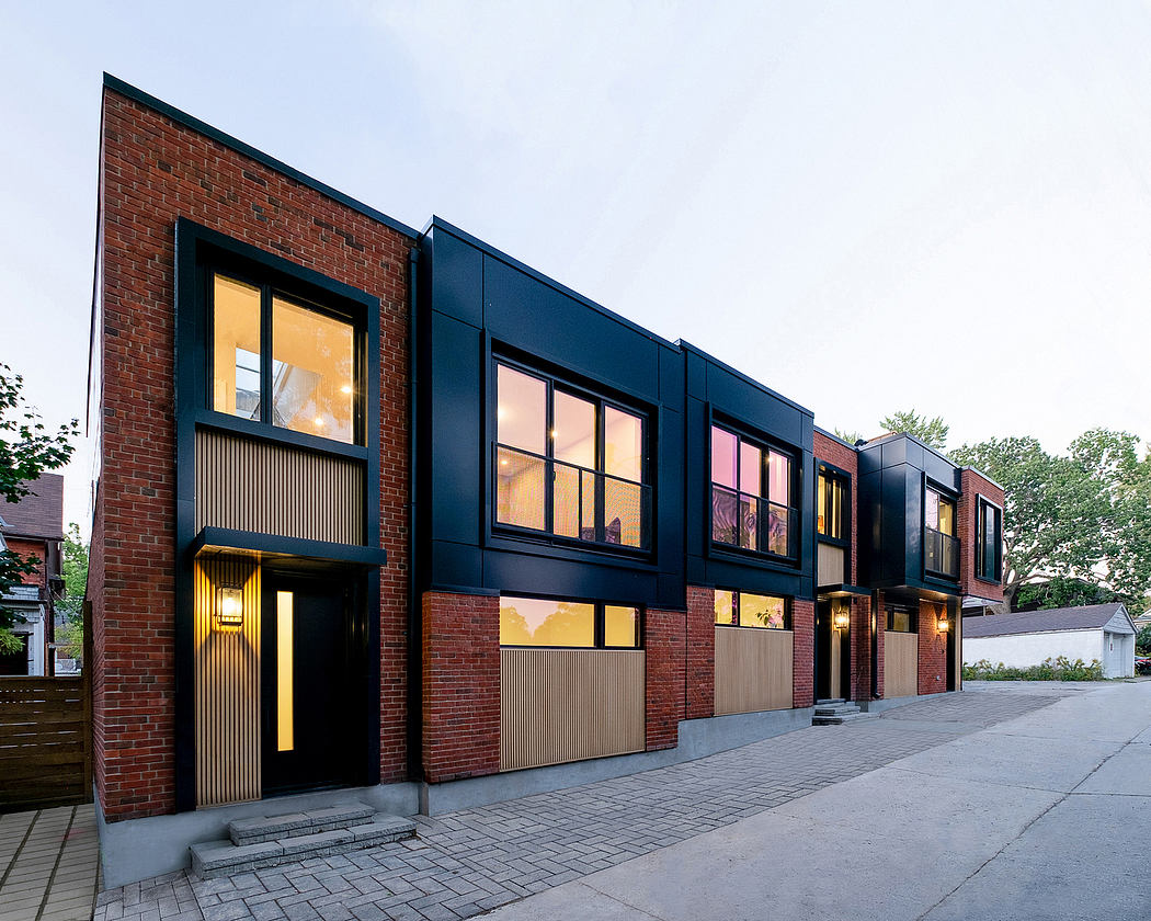 A modern brick and glass building with clean lines and warm interior lighting.