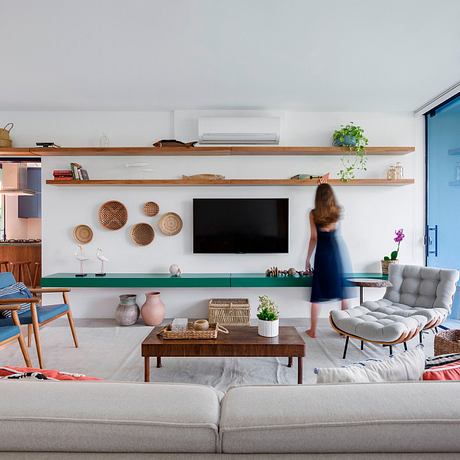 Cozy living room with wooden shelves, TV, and woven decor accents creating a warm, inviting space.