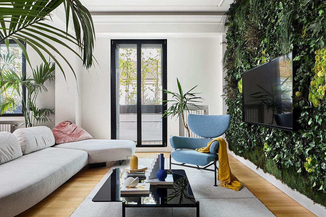 Minimalist living room with large windows, palm plants, and a gray modular sofa.