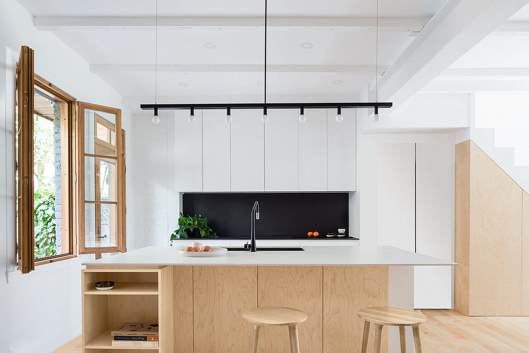 Modern kitchen with minimalist white cabinetry, wooden accents, and track lighting.
