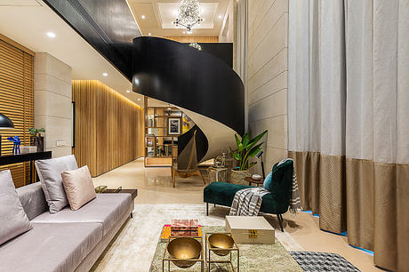 Luxurious living room with curved spiral staircase, wood paneling, and statement lighting.