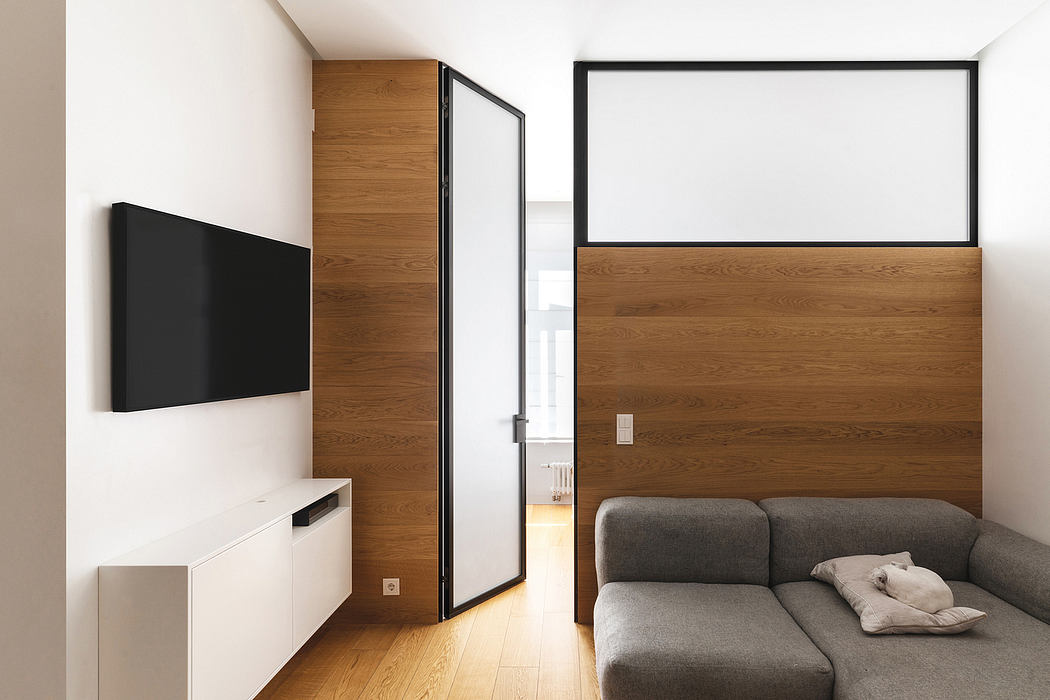 Sleek, modern living room with minimalist furniture, wood paneling, and a large projection screen.