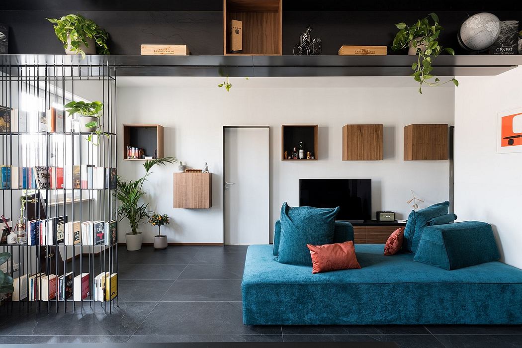 Minimalist living room with blue velvet sofa, shelves, and potted plants.