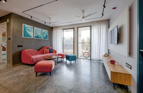 Spacious living room with modern furniture, abstract wall art, and floor-to-ceiling windows.