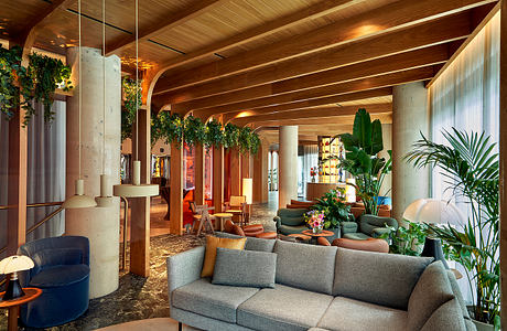 Spacious, rustic-chic lobby with wooden beams, greenery, and plush seating areas.