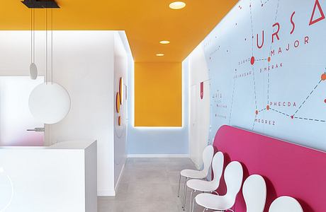 Vibrant orange hallway with geometric lighting fixtures and a stylized wall map.