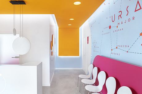 Vibrant orange hallway with geometric lighting fixtures and a stylized wall map.